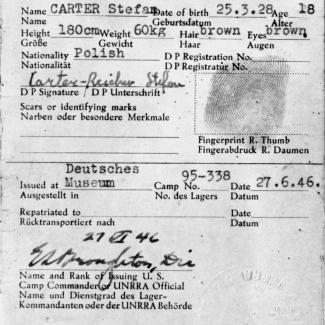 Un formulaire de couleur grise foncée avec un texte de couleur blanche qui identifie principalement le nom, la date de naissance, la nationalité et l'apparence physique d'un individu. Le document est signé et estampé d'empreintes digitales et d'un sceau officiel.